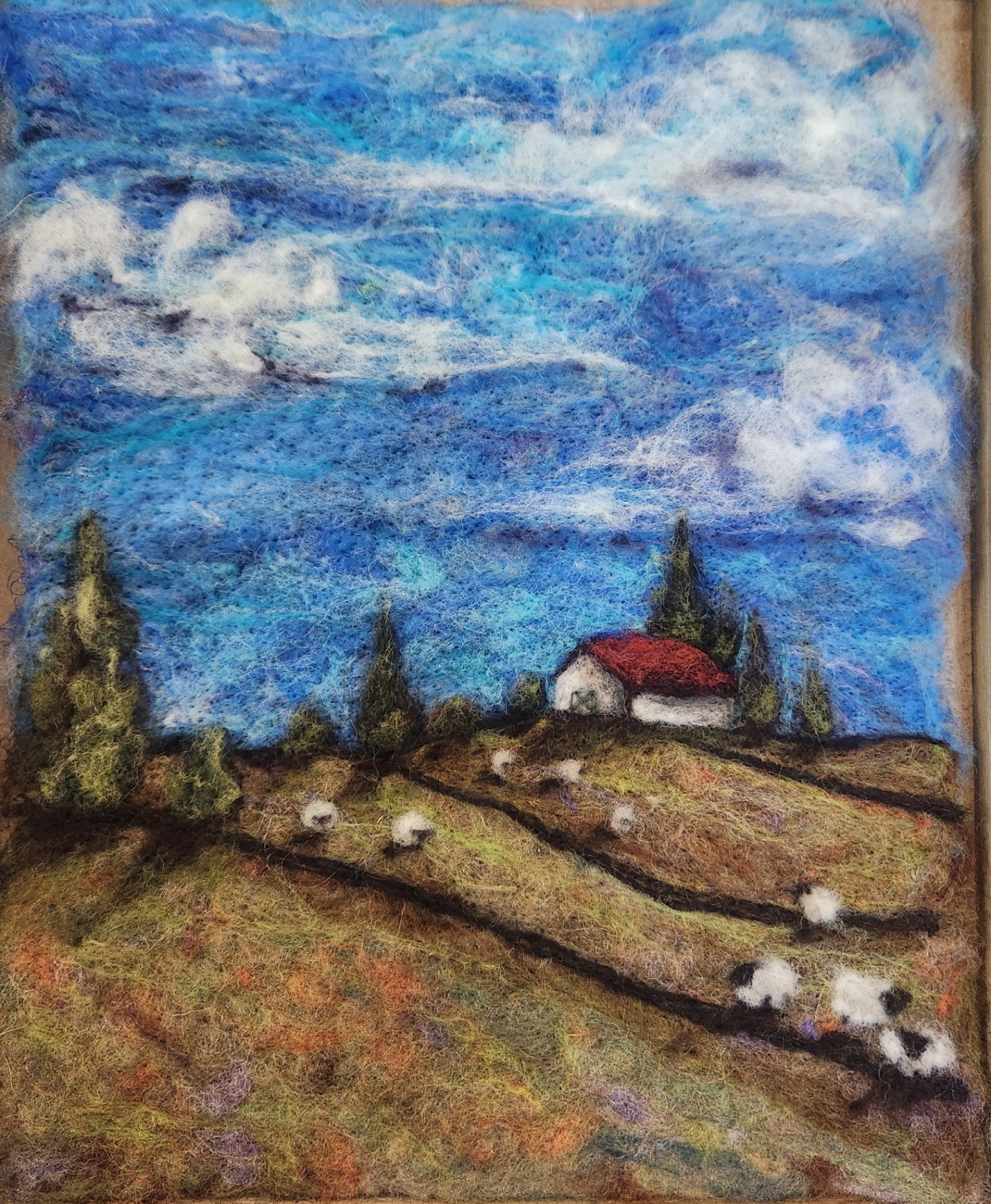 Needle-felted shepherd and hills landscape
